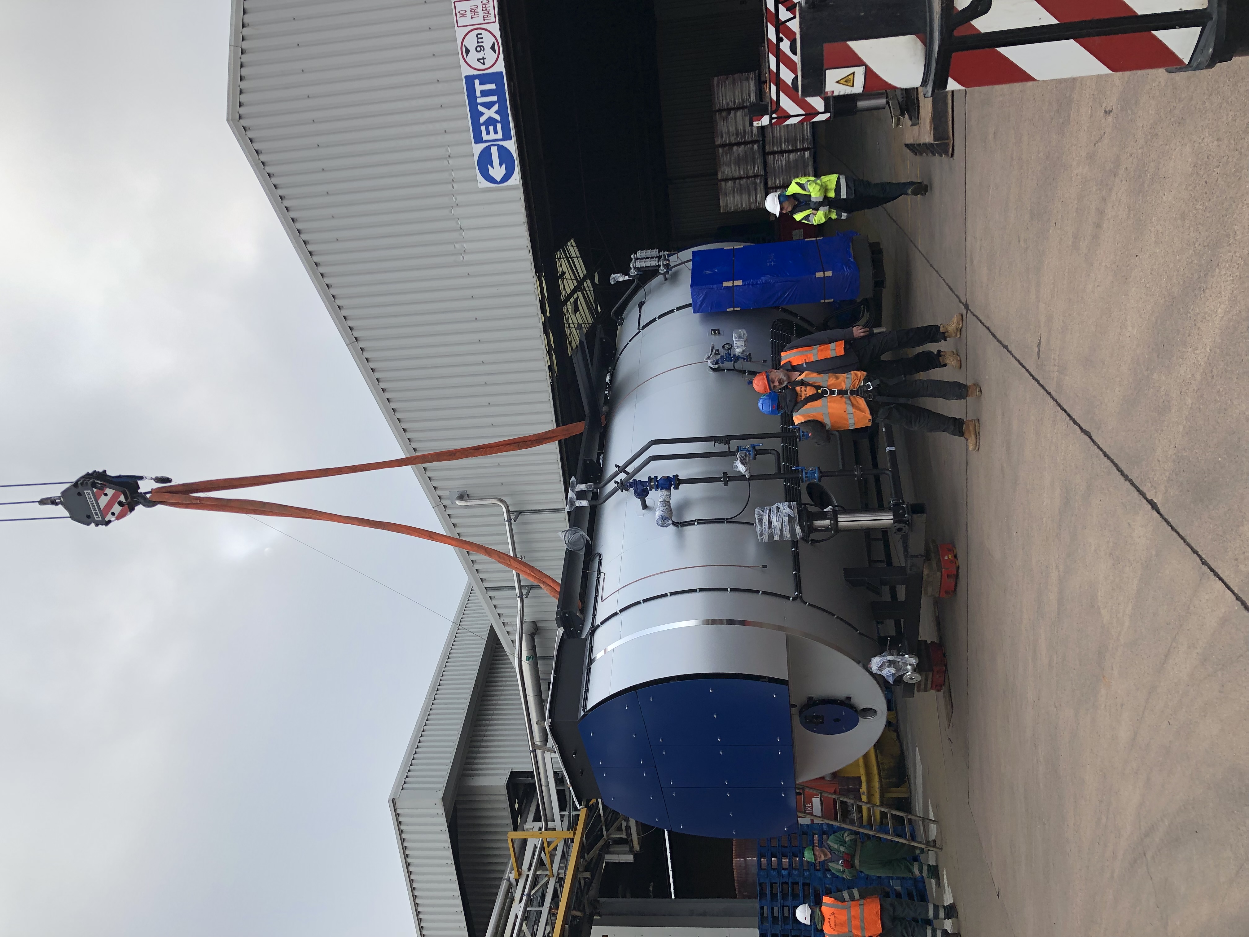 Industrial boiler being positioned by crane during an installation